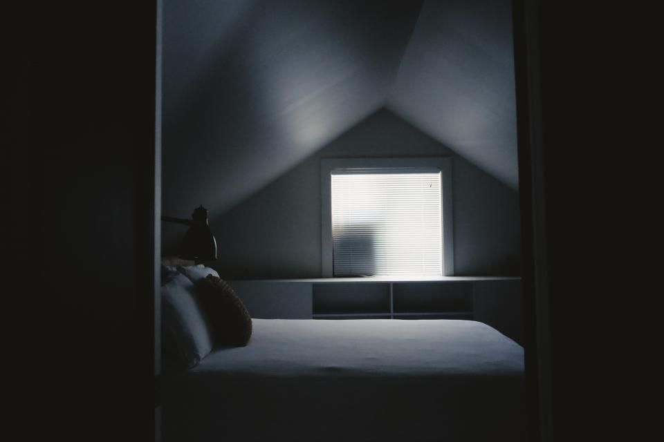A guest room with a large bed and soft lighting